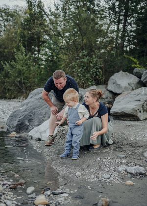 Eltern spielen mit ihrem kleinen Sohn am Ufer der Gail